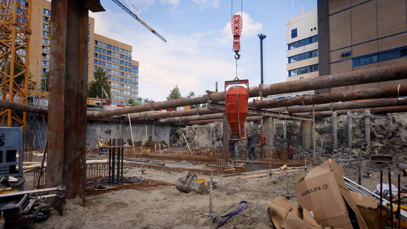 Een betonkubel komt aan in de bouwput
